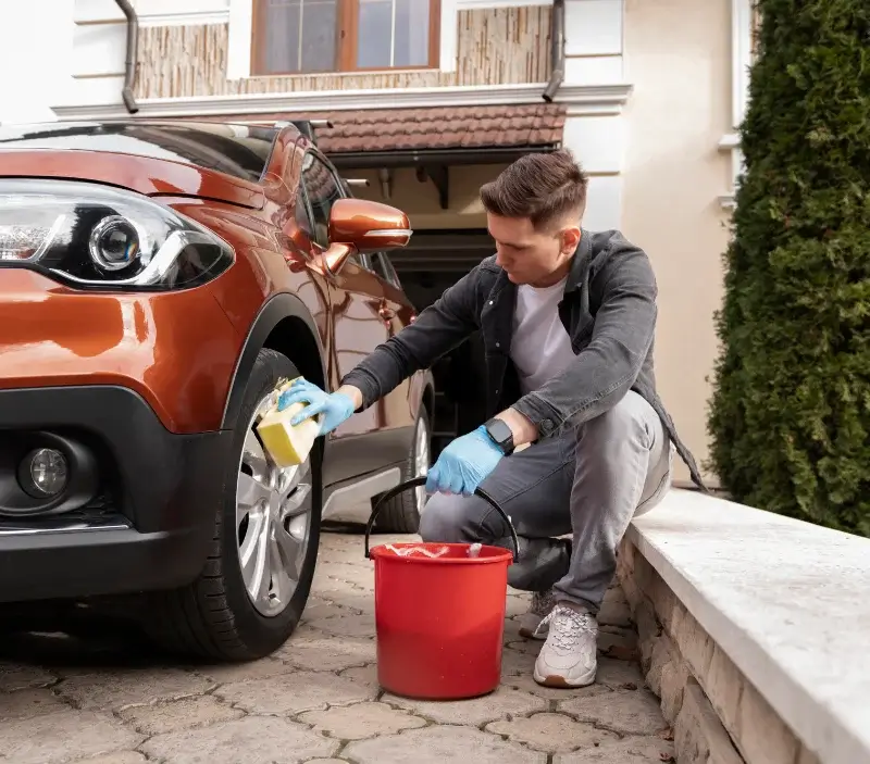 Lavage auto à domicile Crennes-sur-Fraubée : professionnel intervenant sur un véhicule